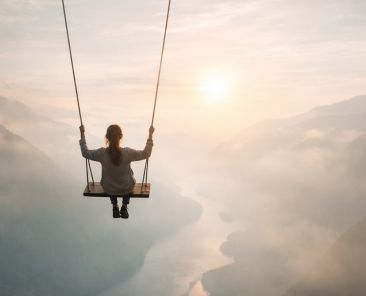 femme qui fait de la balançoire suspendu dans les airs en dessous le vide et de l'eau. Elle exprime son courage est la confiance en soi
