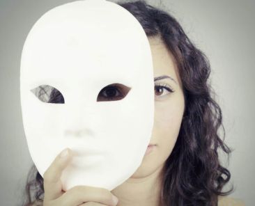 femme qui se cache derrière un masque blanc pour exprimer une autre personnalité