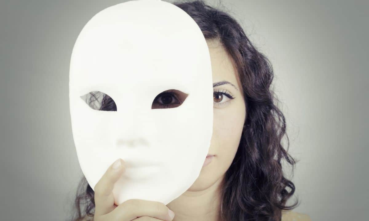 femme qui se cache derrière un masque blanc pour exprimer une autre personnalité