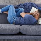 homme blottit sur un canapé ne passe pas à l'action à cause d'un blocage émotionnel